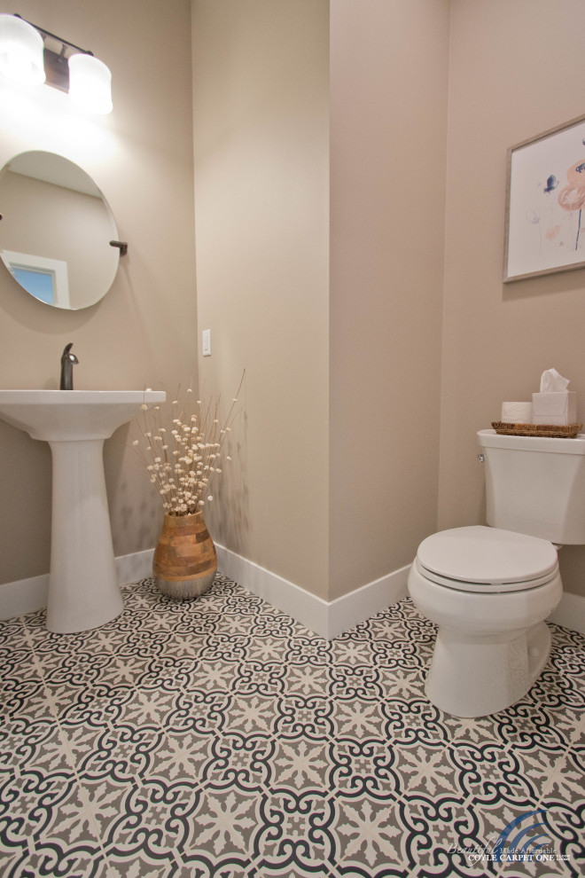 Imagen de aseo de pie actual pequeño con sanitario de dos piezas, paredes beige, suelo de baldosas de porcelana, lavabo con pedestal y suelo multicolor