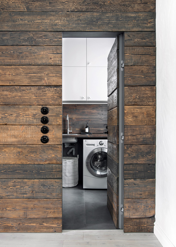 Idéer för små nordiska linjära brunt tvättstugor enbart för tvätt, med släta luckor, vita skåp, träbänkskiva, grå väggar, klinkergolv i porslin och grått golv