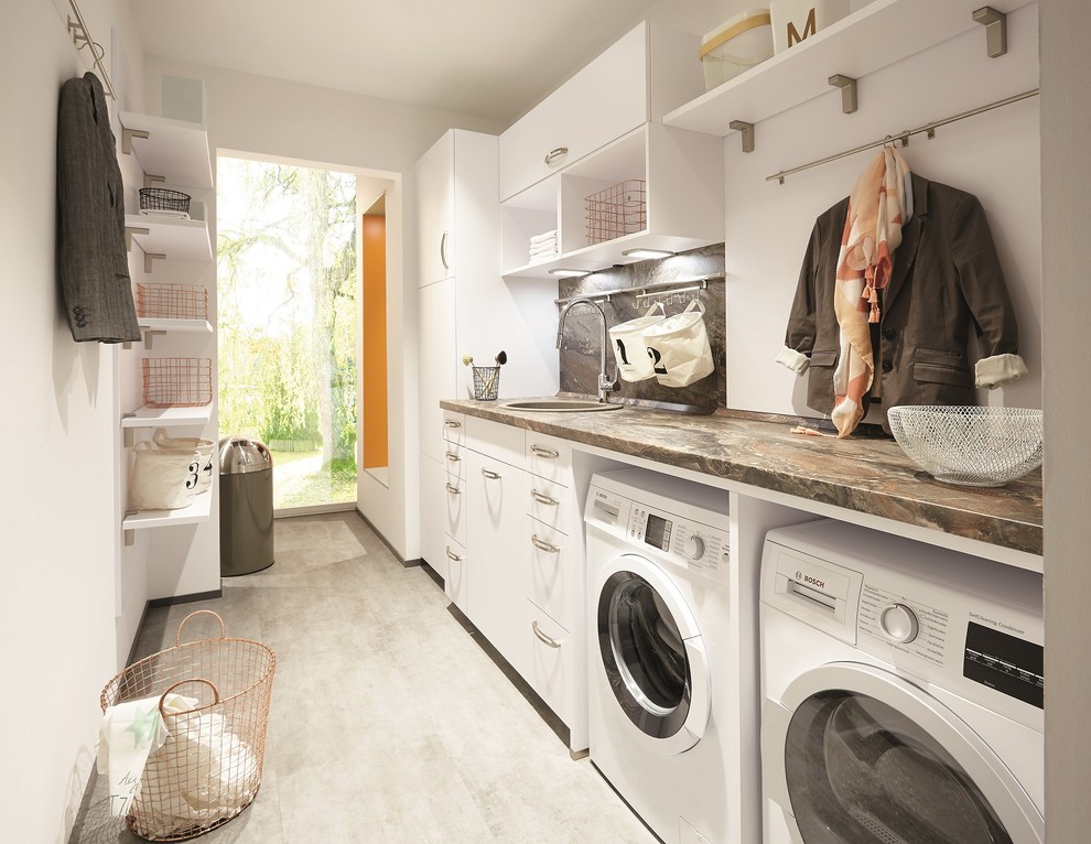 Exempel på en modern linjär tvättstuga enbart för tvätt, med en enkel diskho, släta luckor, vita skåp, laminatbänkskiva, vita väggar, klinkergolv i porslin och en tvättmaskin och torktumlare bredvid varandra