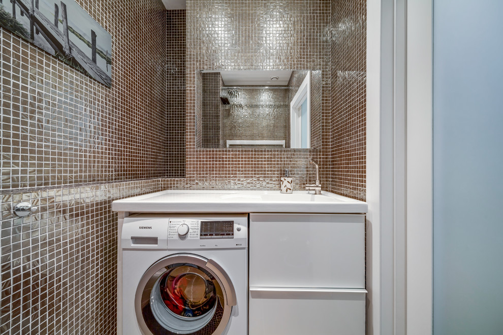 Einzeiliger Moderner Hauswirtschaftsraum mit integriertem Waschbecken, flächenbündigen Schrankfronten, weißen Schränken, brauner Wandfarbe, Waschmaschinenschrank und Waschmaschine und Trockner integriert in Jekaterinburg