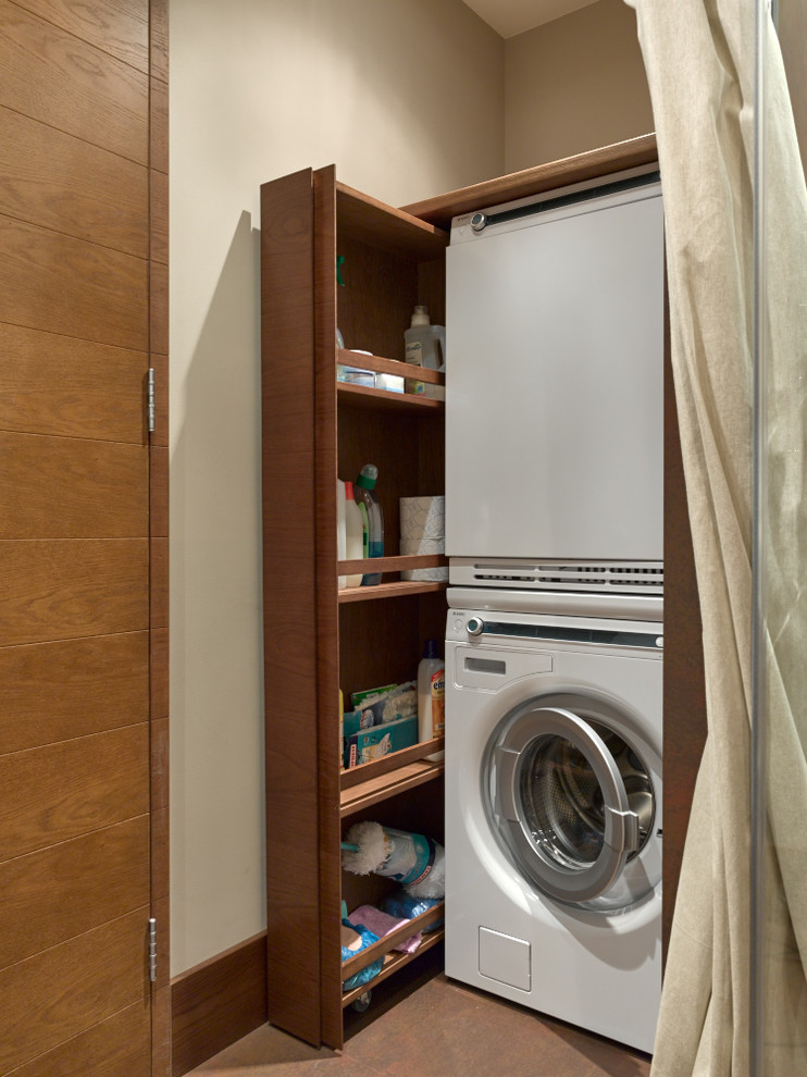 Photo of a contemporary utility room in Moscow with a stacked washer and dryer.