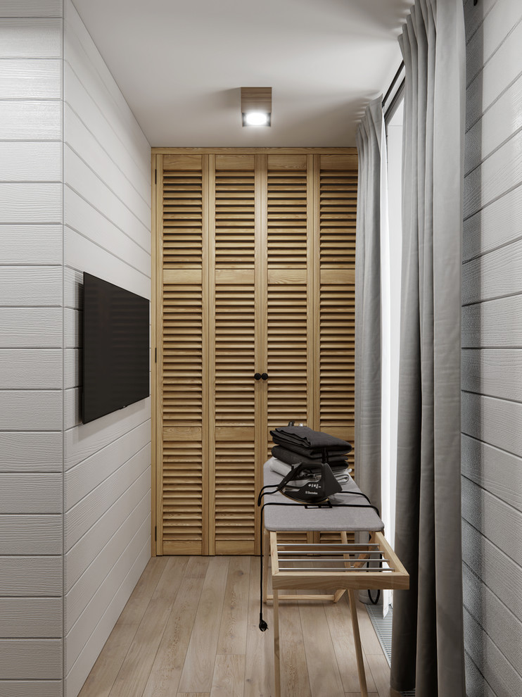 Immagine di una piccola sala lavanderia country con ante a persiana, ante in legno chiaro, pareti bianche, pavimento con piastrelle in ceramica, lavatrice e asciugatrice nascoste e pavimento beige