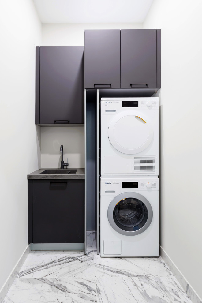 Exempel på en liten modern grå linjär grått tvättstuga enbart för tvätt, med en undermonterad diskho, släta luckor, vita väggar, marmorgolv, en tvättpelare, vitt golv och grå skåp