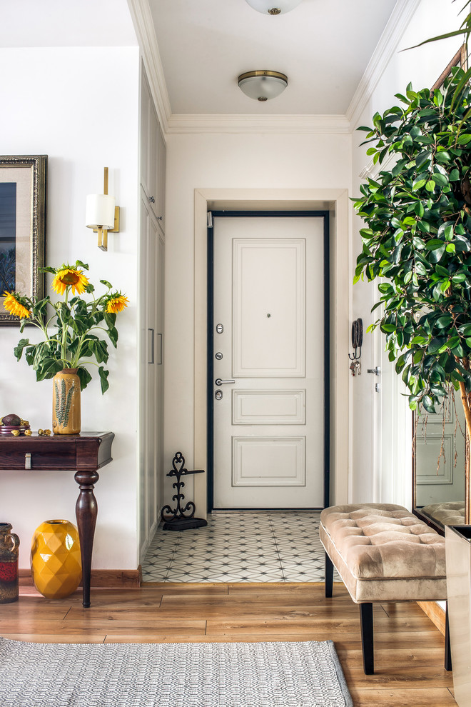 Cette photo montre une porte d'entrée chic de taille moyenne avec un mur blanc, un sol en carrelage de porcelaine, une porte simple et une porte blanche.
