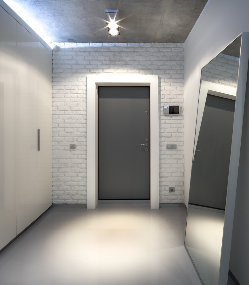 Idee per un ingresso o corridoio minimal di medie dimensioni con pareti bianche, pavimento in cemento e pavimento grigio