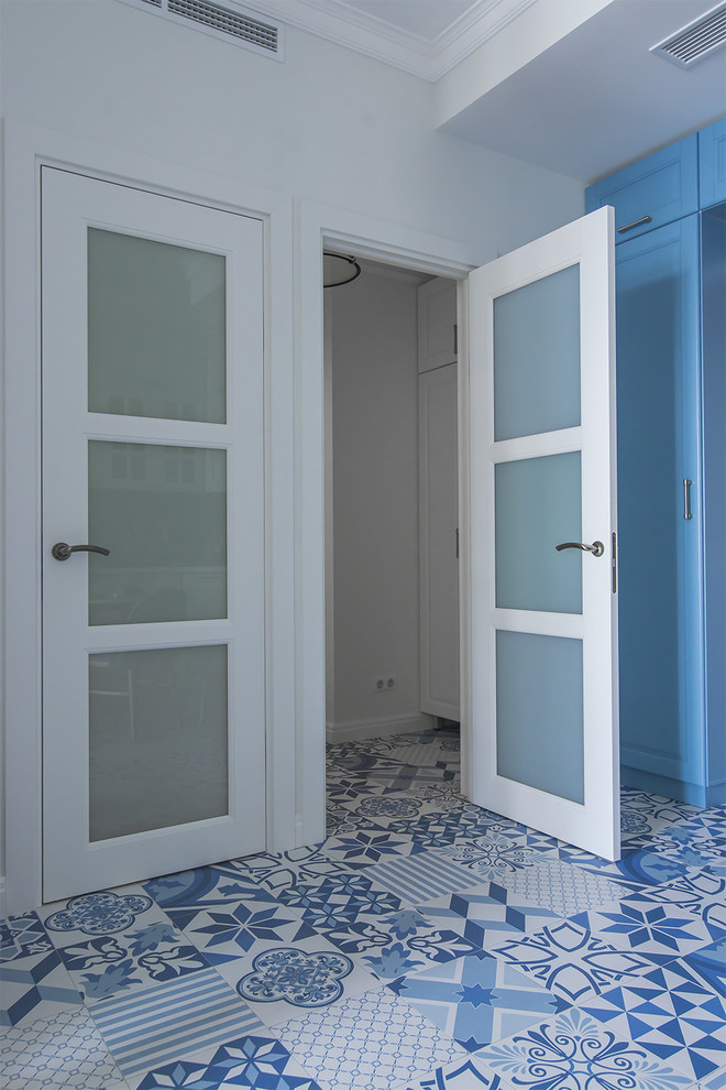 他の地域にある小さなビーチスタイルのおしゃれな玄関 (白い壁、磁器タイルの床、青い床) の写真