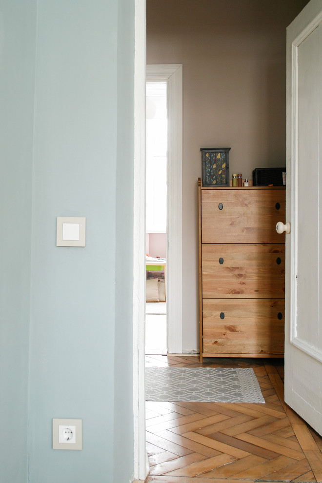 Foto de distribuidor escandinavo pequeño con paredes beige, suelo de madera en tonos medios, puerta simple y suelo beige