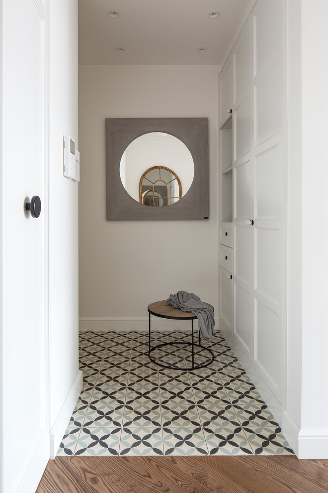 Cette photo montre une entrée chic avec un couloir, un mur blanc et un sol multicolore.