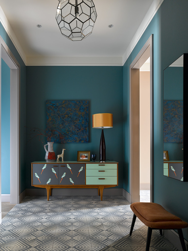 Foto på en funkis entré, med blå väggar och flerfärgat golv