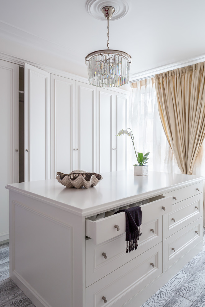 Стильный дизайн: встроенный шкаф среднего размера, унисекс в скандинавском стиле с фасадами с выступающей филенкой, белыми фасадами, полом из керамогранита, серым полом и деревянным потолком - последний тренд