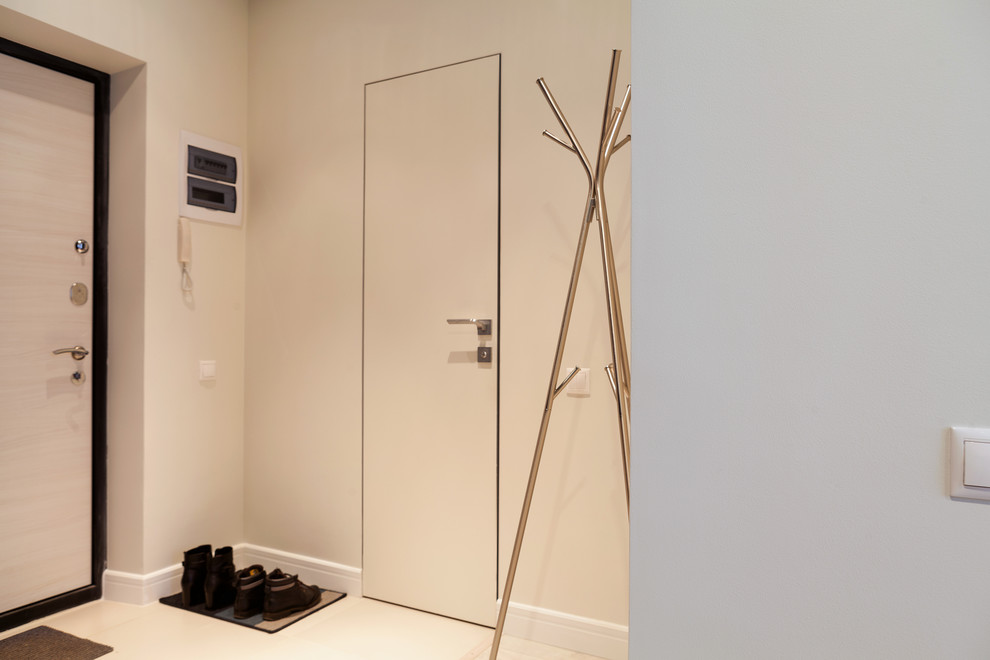 他の地域にある低価格の小さなコンテンポラリースタイルのおしゃれな玄関ドア (ベージュの壁、磁器タイルの床、淡色木目調のドア、ベージュの床) の写真