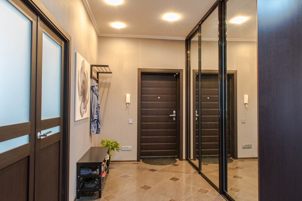 На фото: входная дверь среднего размера в современном стиле с бежевыми стенами, полом из керамической плитки, одностворчатой входной дверью и входной дверью из темного дерева