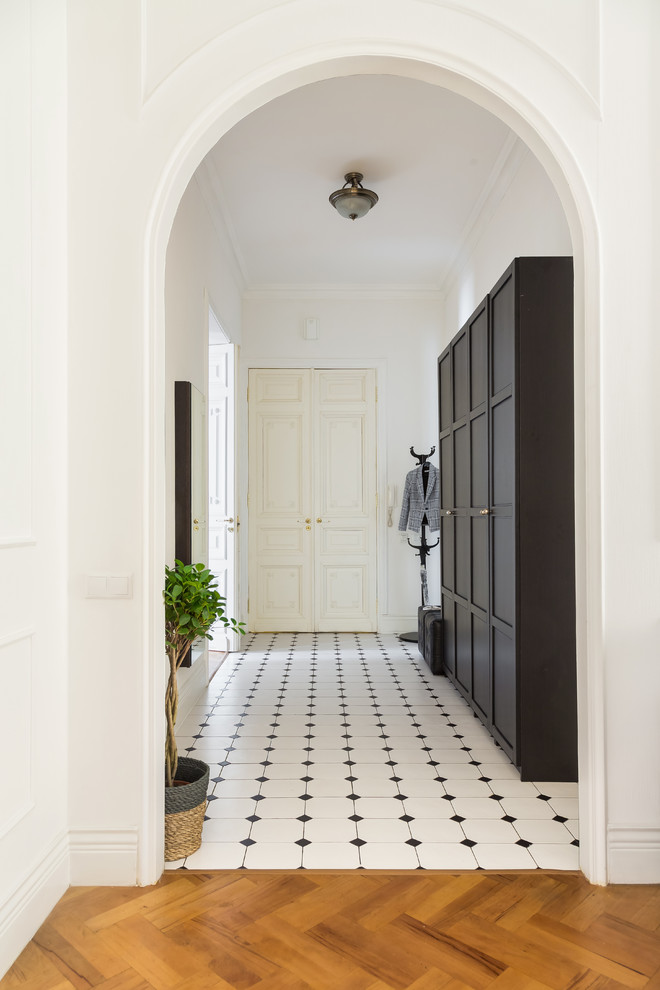 На фото: большая входная дверь: освещение с белыми стенами, полом из керамической плитки, двустворчатой входной дверью, белой входной дверью и белым полом