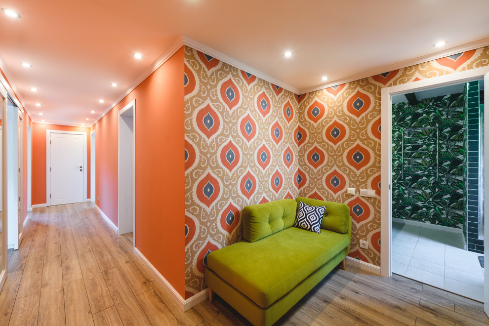 Стильный дизайн: узкая прихожая среднего размера с оранжевыми стенами, полом из ламината, бежевым полом и обоями на стенах - последний тренд