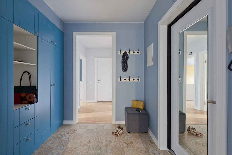 Moderner Eingang mit Korridor, blauer Wandfarbe, Porzellan-Bodenfliesen und weißer Haustür in Sankt Petersburg