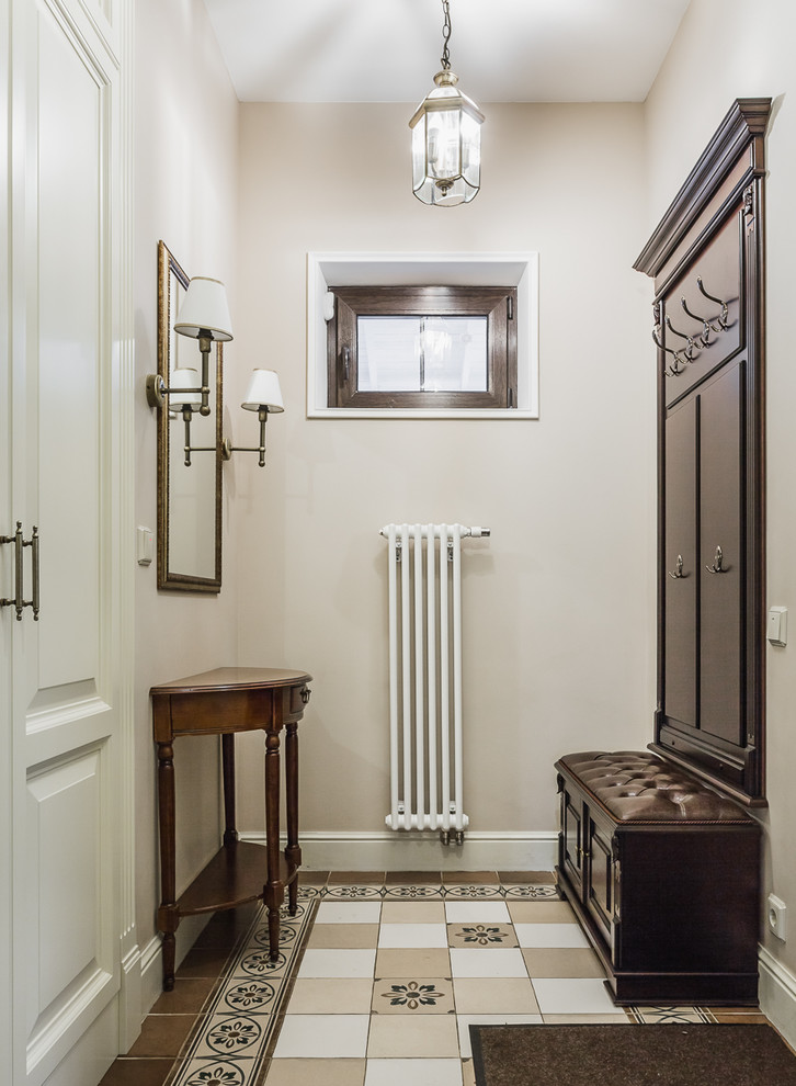 Bild på ett mellanstort vintage kapprum, med beige väggar, flerfärgat golv, klinkergolv i porslin, en enkeldörr och en vit dörr