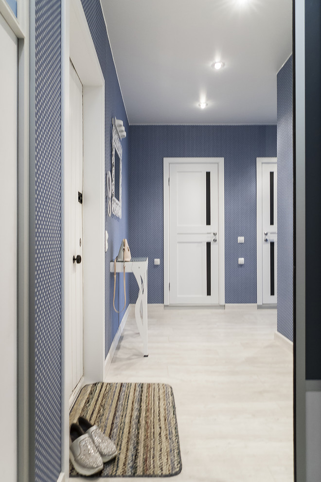 サンクトペテルブルクにある低価格の中くらいなコンテンポラリースタイルのおしゃれな玄関ドア (青い壁、クッションフロア、白いドア、グレーの床、壁紙) の写真