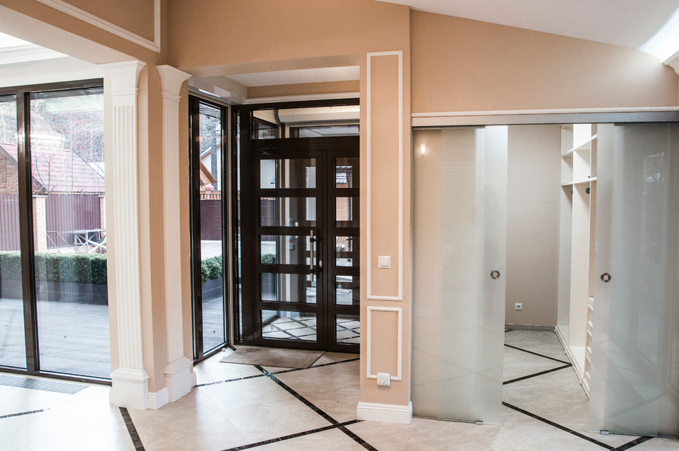 Modelo de entrada clásica renovada de tamaño medio con paredes beige, suelo de baldosas de porcelana, puerta simple, puerta marrón y suelo beige
