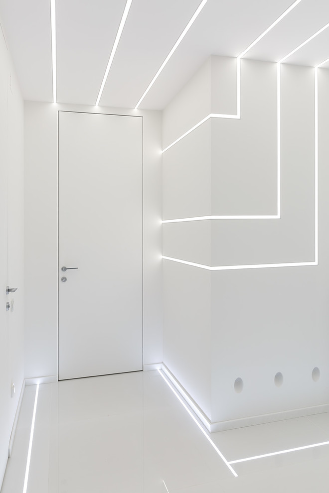 Ispirazione per un piccolo corridoio design con pareti bianche, pavimento in gres porcellanato e pavimento bianco