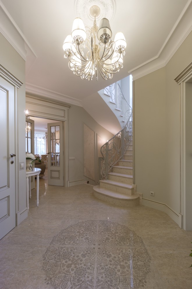 Ejemplo de vestíbulo tradicional grande con paredes beige, suelo de baldosas de porcelana, puerta simple, puerta blanca y suelo beige
