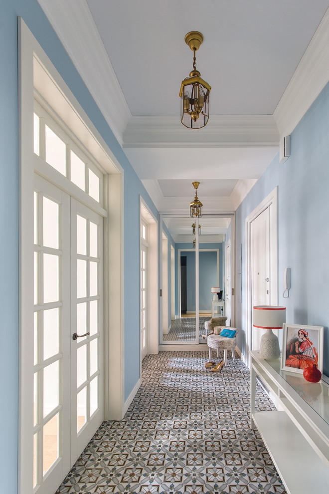 Foto på en stor vintage hall, med blå väggar, klinkergolv i keramik, en vit dörr och en enkeldörr