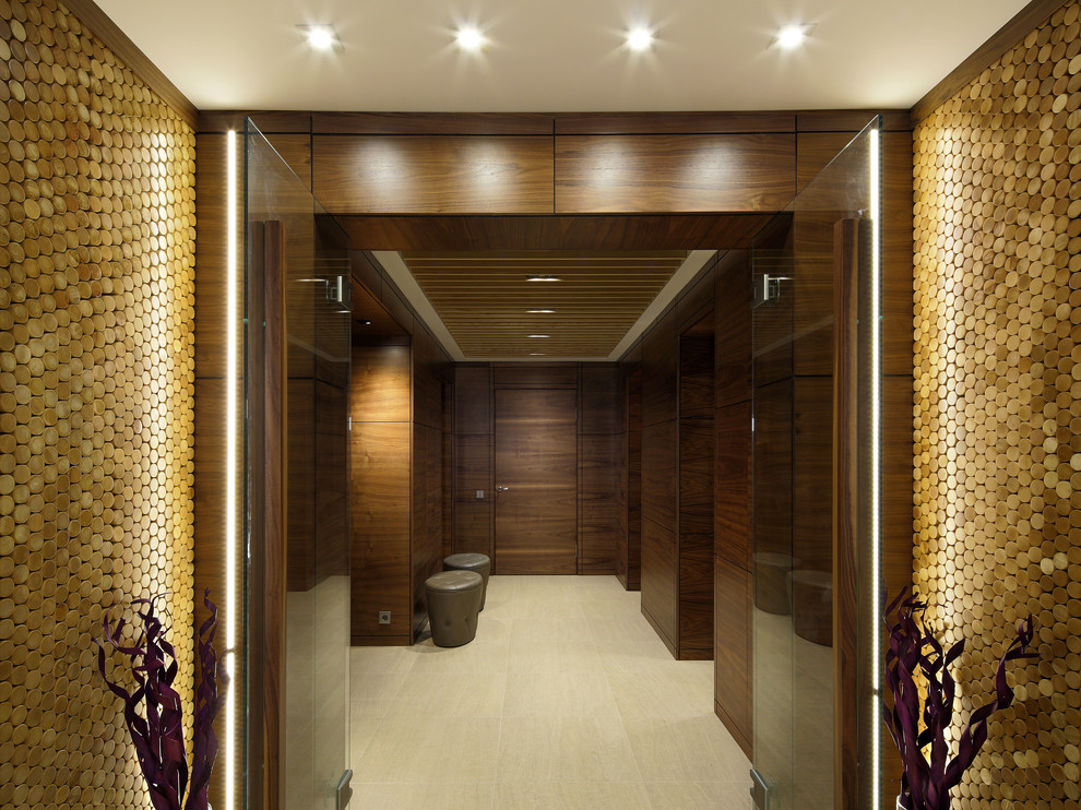 Cette image montre une grande entrée design avec un vestiaire, un mur marron, un sol en carrelage de porcelaine et une porte double.