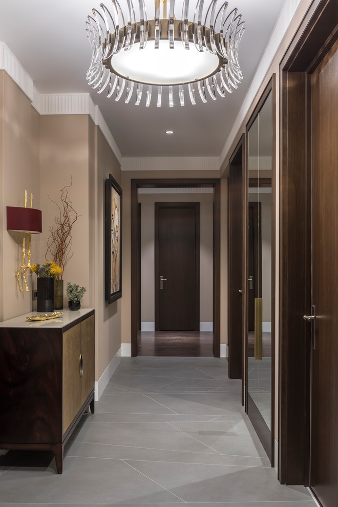 Example of a mid-sized transitional porcelain tile and gray floor entryway design in Moscow with beige walls and a dark wood front door