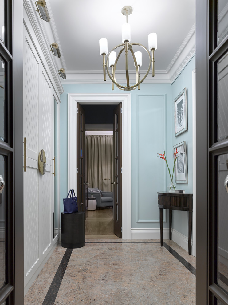 Inspiration pour une petite entrée traditionnelle avec un couloir, un mur bleu, sol en granite, une porte marron et un sol marron.
