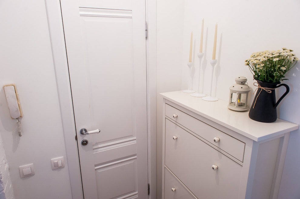Modelo de hall nórdico pequeño con paredes blancas, suelo laminado, puerta simple, puerta blanca y suelo marrón