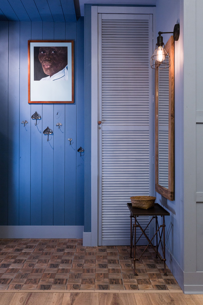 Exempel på en liten eklektisk entré, med blå väggar