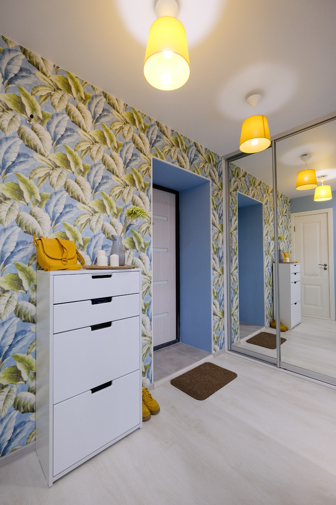 Diseño de hall nórdico pequeño con paredes azules, suelo laminado, puerta blanca y suelo beige