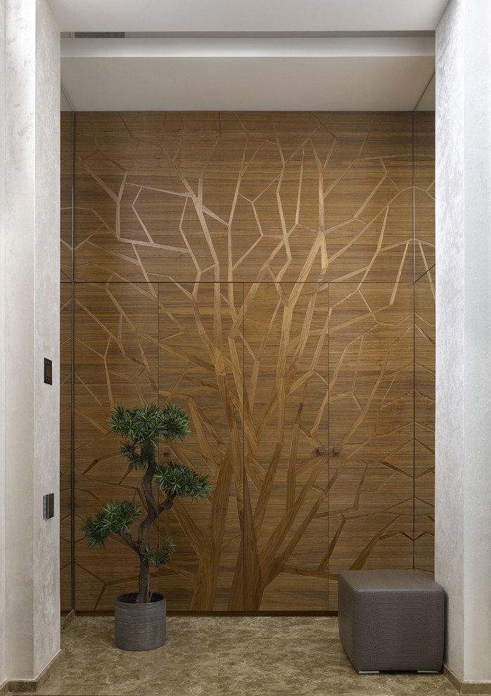 Ispirazione per un ingresso con vestibolo design con pareti con effetto metallico, pavimento in marmo, una porta in legno bruno e pavimento beige