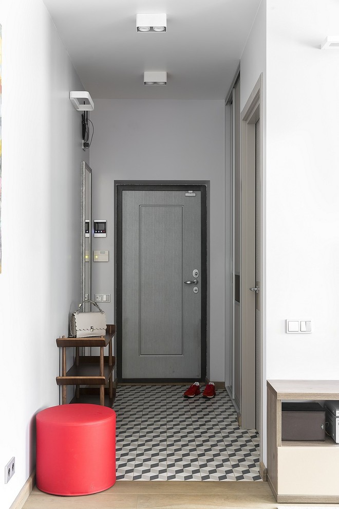 Moderner Eingang mit Keramikboden, grauer Haustür, Einzeltür, Korridor, weißer Wandfarbe und buntem Boden in Moskau