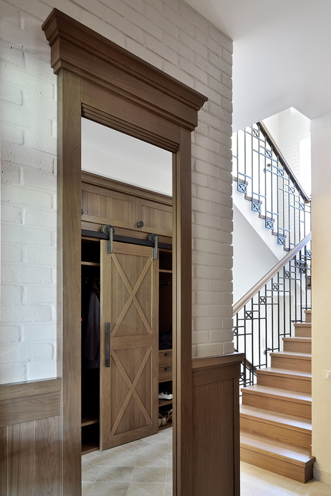 Ejemplo de vestíbulo de tamaño medio con paredes blancas, suelo de baldosas de cerámica, puerta simple, puerta de madera en tonos medios y suelo gris