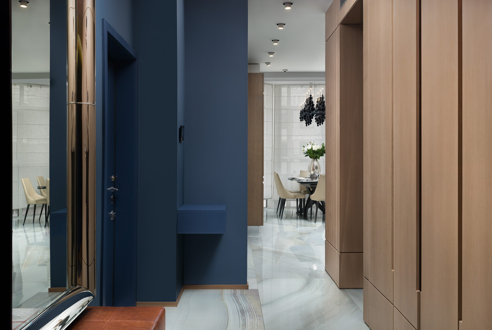 Diseño de hall actual con paredes azules, puerta simple, puerta azul y suelo blanco