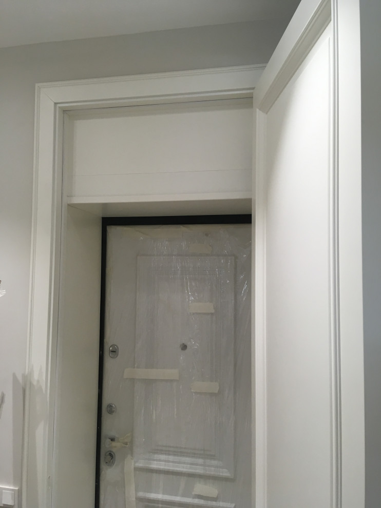 Foto de puerta principal clásica grande con paredes grises, suelo laminado, puerta simple, puerta blanca, suelo beige y boiserie