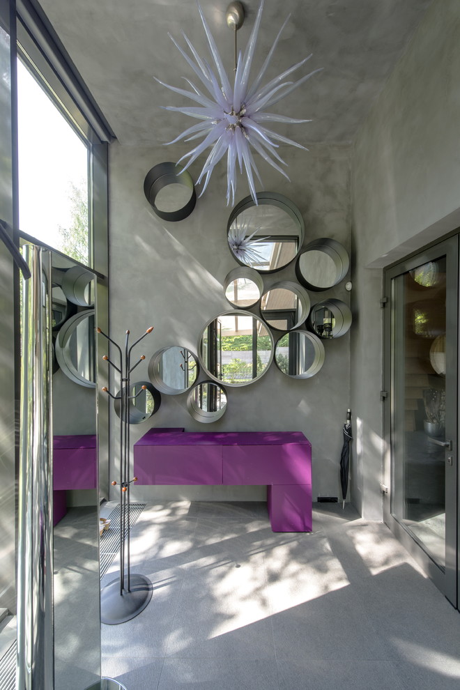 Réalisation d'une grande entrée design avec un mur gris, un sol en carrelage de porcelaine et une porte en verre.