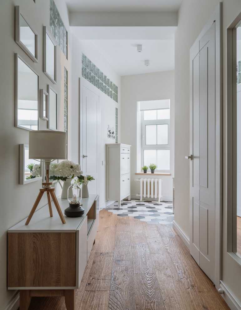 Источник вдохновения для домашнего уюта: большая узкая прихожая в скандинавском стиле с одностворчатой входной дверью и белой входной дверью