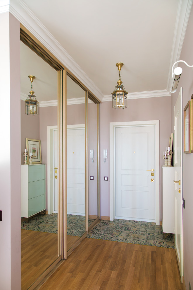 Modelo de puerta principal contemporánea pequeña con paredes rosas, puerta simple, puerta blanca y suelo de madera en tonos medios