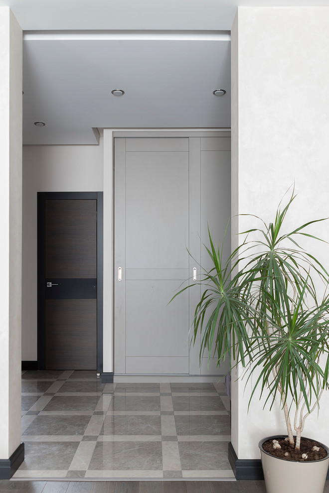Idee per un ingresso chic di medie dimensioni con pareti beige, pavimento in gres porcellanato, una porta singola, pavimento grigio e una porta in legno scuro