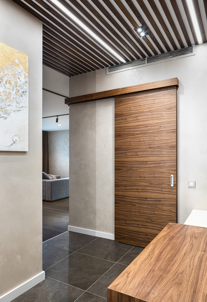 Example of a mid-sized trendy porcelain tile and brown floor entryway design in Moscow with beige walls and a medium wood front door