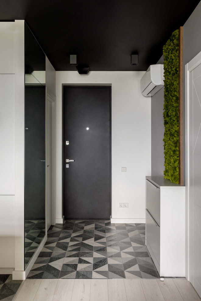 Источник вдохновения для домашнего уюта: прихожая в скандинавском стиле с серыми стенами, одностворчатой входной дверью, черной входной дверью и серым полом
