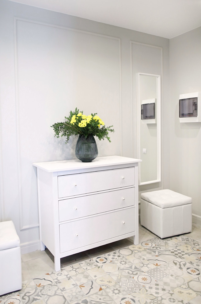 Exemple d'une grande entrée tendance avec un couloir, un sol en carrelage de porcelaine, un sol multicolore et un mur gris.