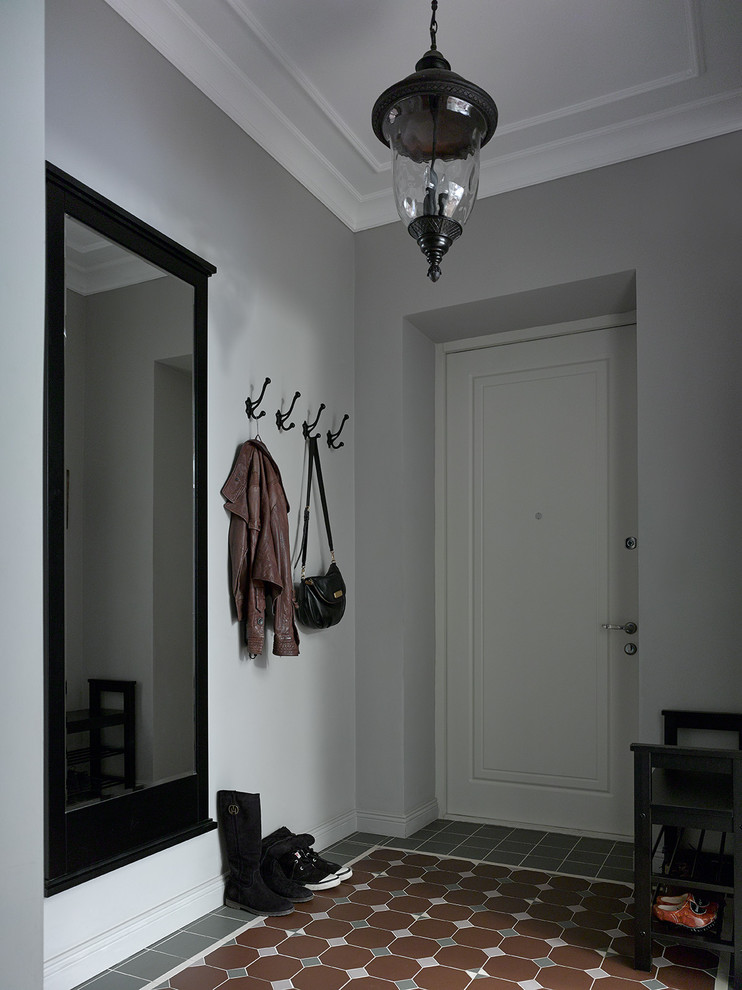 Idées déco pour une porte d'entrée classique avec un mur gris, une porte simple, une porte blanche et un sol multicolore.