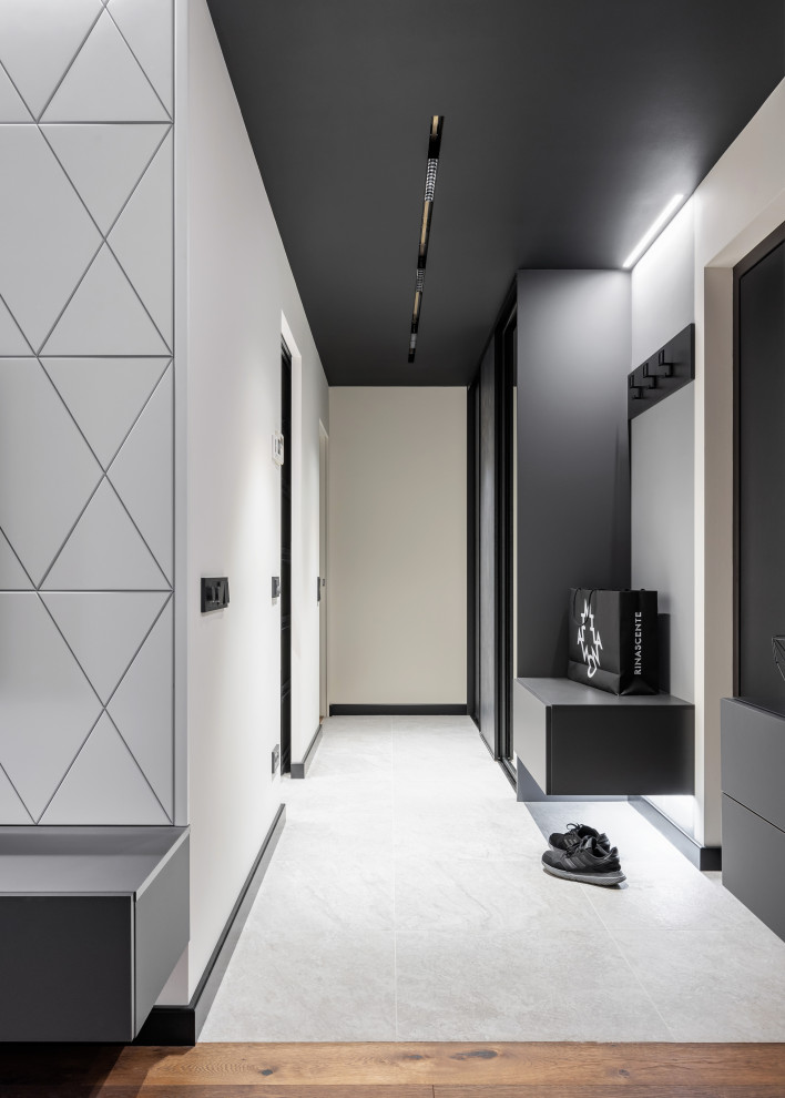 Cette image montre une petite entrée design avec un couloir, un mur gris, un sol en carrelage de porcelaine, une porte simple et un sol gris.