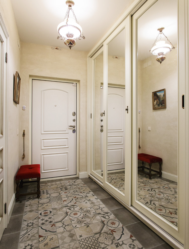Cette photo montre une porte d'entrée tendance avec un mur beige, une porte simple, une porte blanche et un sol gris.