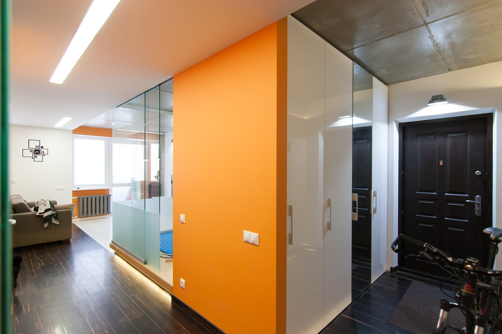 Immagine di un corridoio minimal con pareti arancioni e pavimento in gres porcellanato
