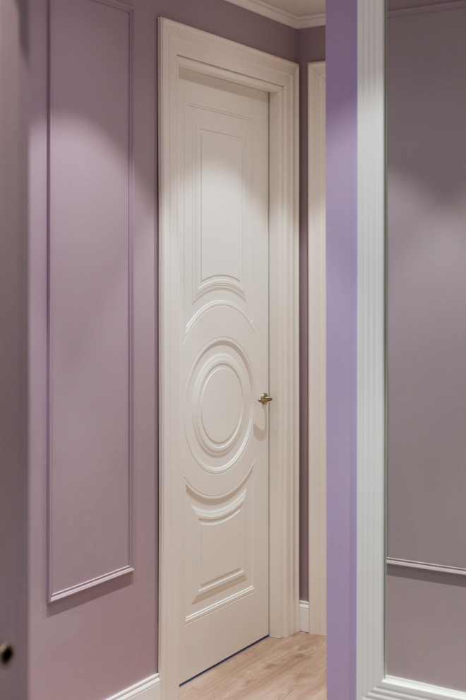 Cette image montre une entrée traditionnelle de taille moyenne avec un couloir, un mur violet, sol en stratifié, une porte simple, une porte blanche et un sol beige.