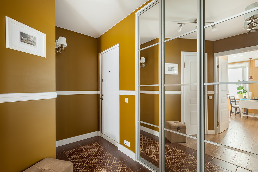 Ispirazione per una porta d'ingresso contemporanea con una porta bianca, pareti gialle e una porta singola
