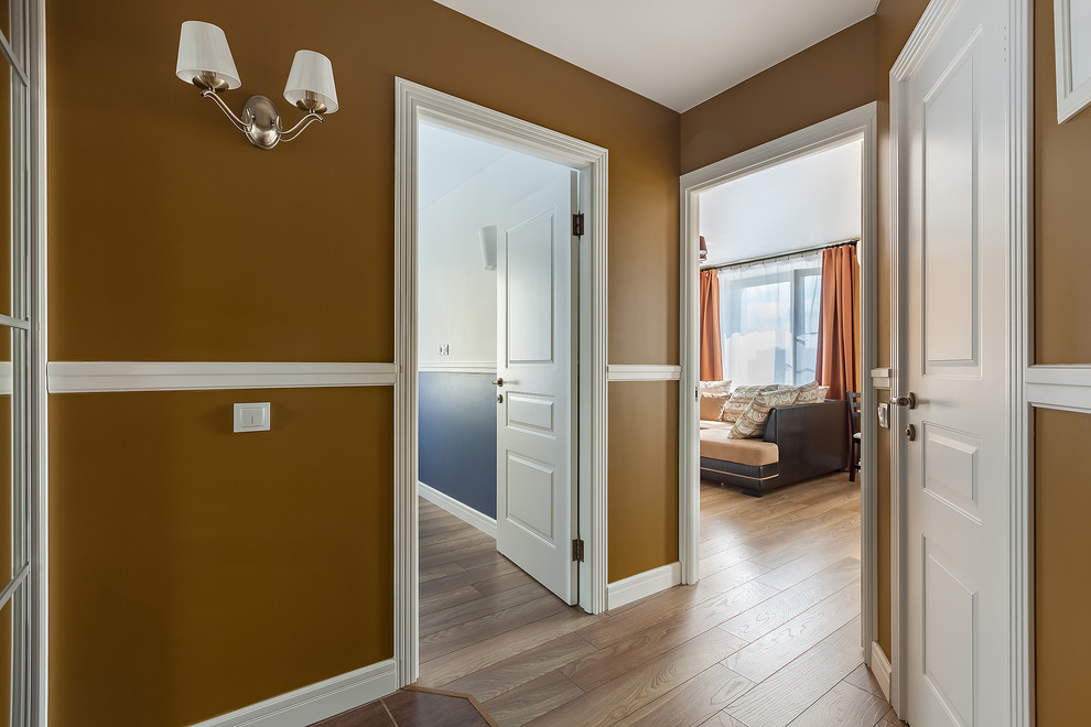 Small classic entrance in Moscow with medium hardwood flooring and yellow walls.
